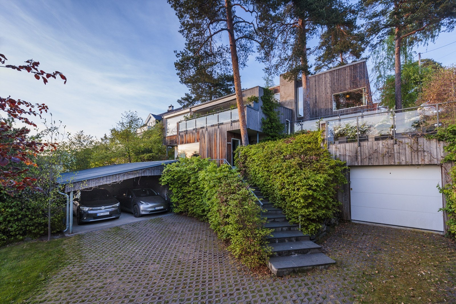 Det er parkering i dobbel carport, innebygd garasje og på gårdsplassen. Carporten har elbillader. Galleribilde