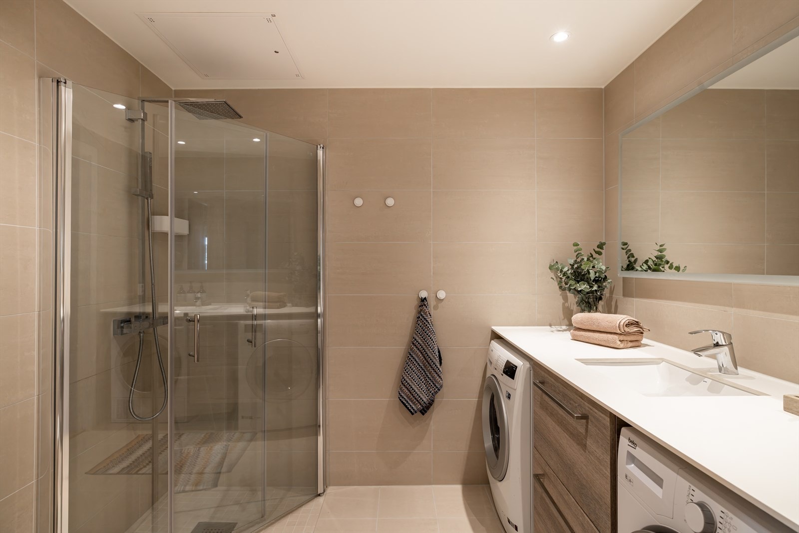 Stort flislagt baderom med dusj og vaskesøyle Galleribilde