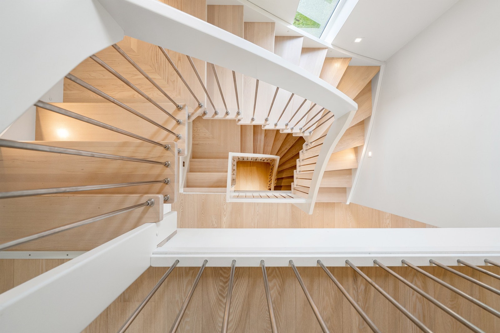 Trappeløp i hvitt matt lakkert ask (samme som gulv i boligen). Innfelt belysning i vegg. Galleribilde