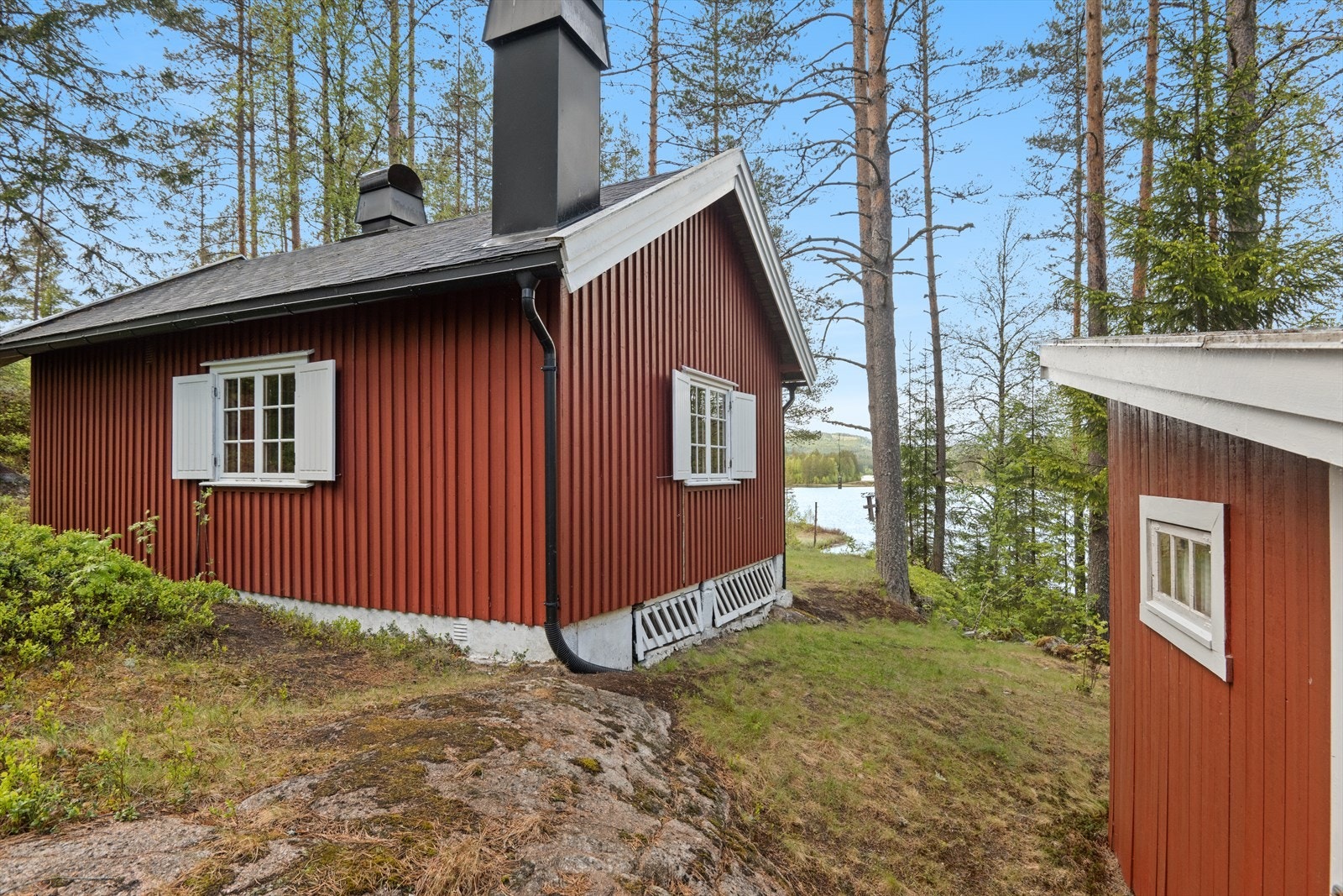 Hytte og uthus/anneks ligger fint dandert på et lite tun. Galleribilde