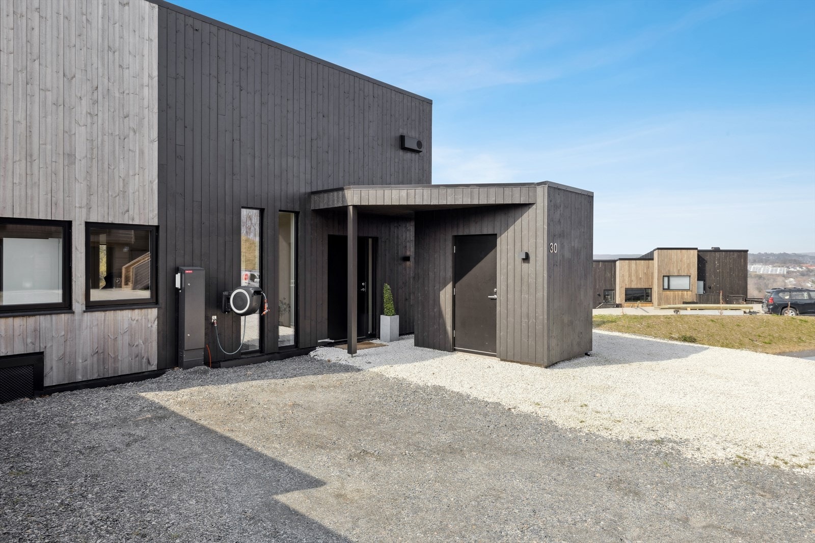 Inngangspartiet er overbygget og tilknyttet en praktisk utvendig bod. Egen carport (bak bod) med el-lader og ellers gode parkeringsmuligheter på tomt. Galleribilde