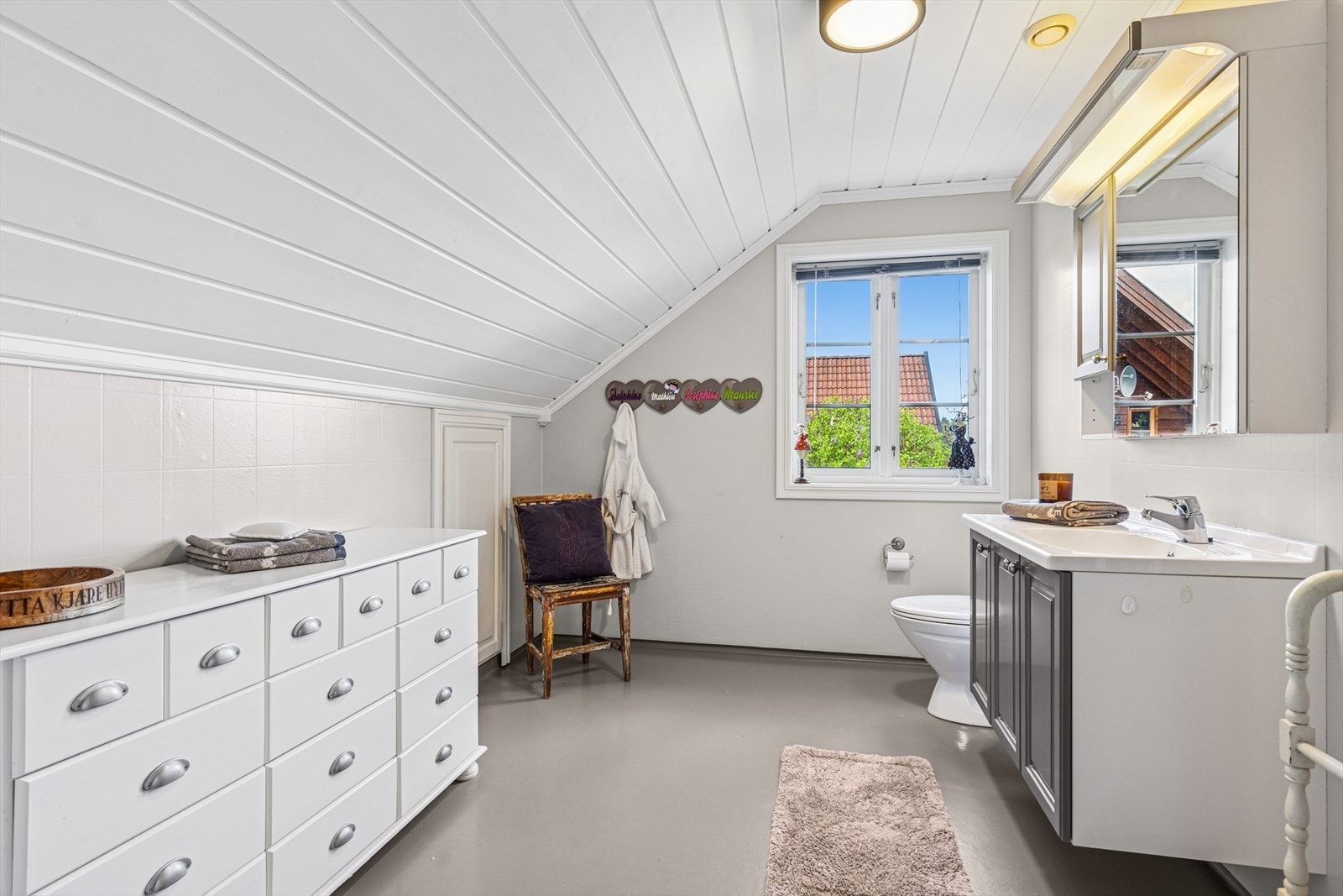 Lyst og luftig baderom på loftet med toalett, servant og dusjkabinett. Galleribilde