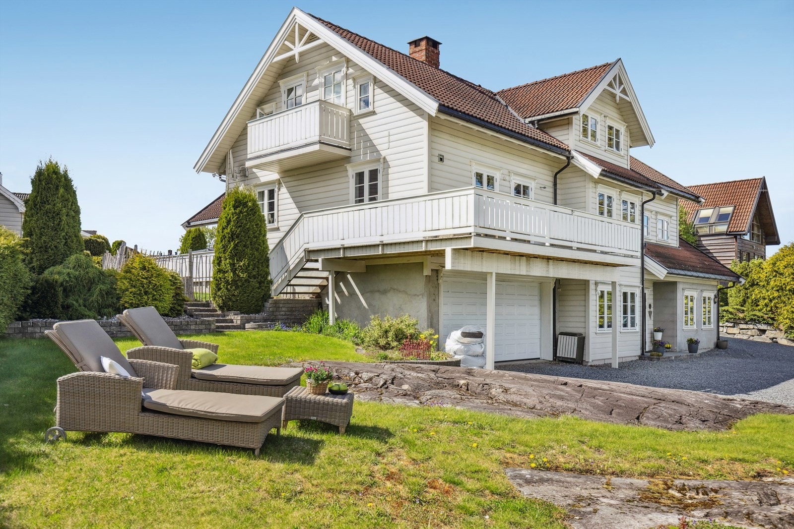 Et klassisk og vakkert hus med hvit fasade og rødt tak. Galleribilde