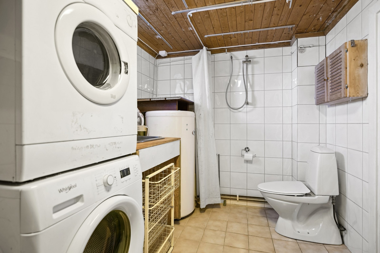 Vaskerommet er flislagt og her finnes dusj, toalett samt opplegg for vaskemaskin og tørketrommel Galleribilde