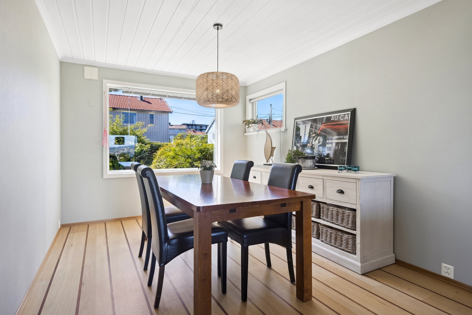 Det store vinduet mot hagen fyller rommet med naturlig lys og skaper en god atmosfære Galleribilde