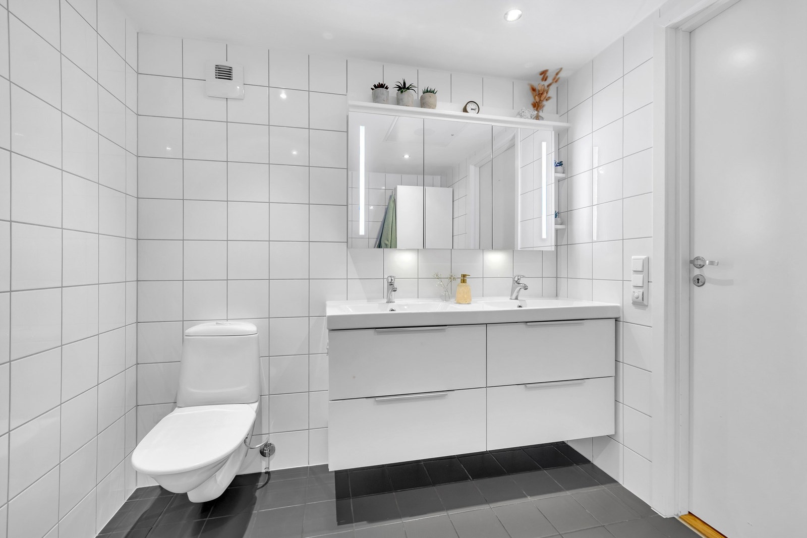 Badet har moderne innredning med dobbel servant samt toalett. Opplegg for vaskemaskin på badet. Galleribilde