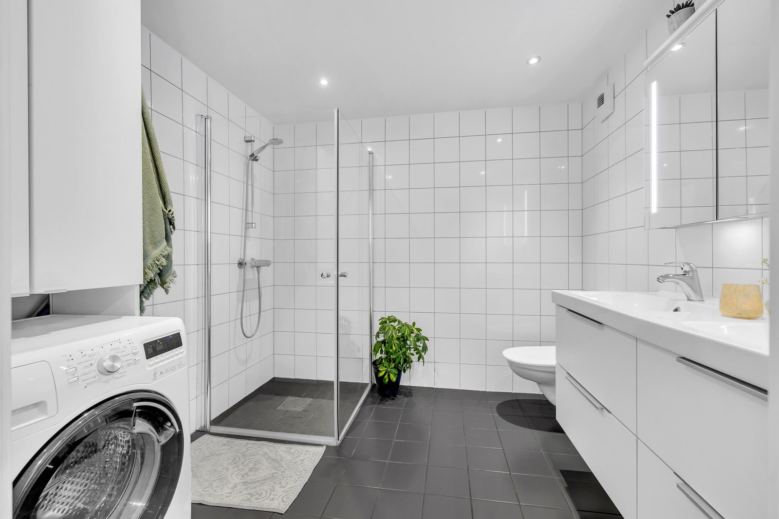 Pent og flislagt bad med vegghengt dusj, innfellbare dusjvegger samt dobbel servant med underskap. Perfekt for travle morgener. Galleribilde