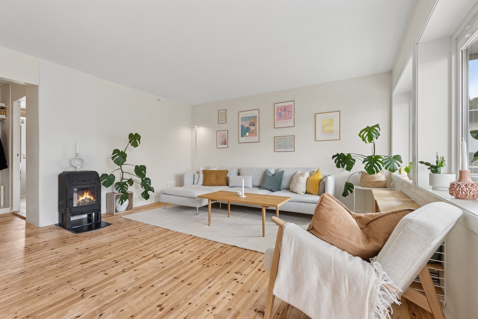 Stuen er lys og luftig med en herlig vedovn Galleribilde