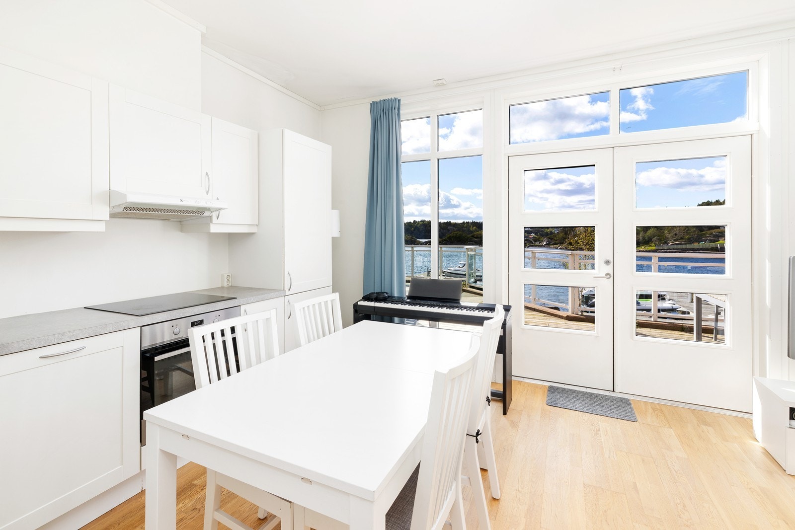 Kjøkken med hvite glatte fronter og laminat benkeplate. Hvitevarer medfølger salget. Galleribilde