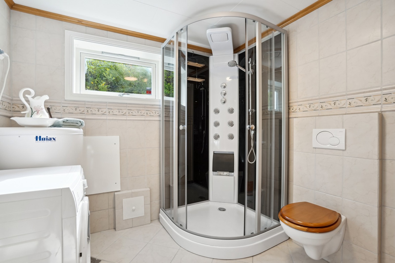 Badet er utstyrt med dusjkabinett og vegghengt toalett. Galleribilde