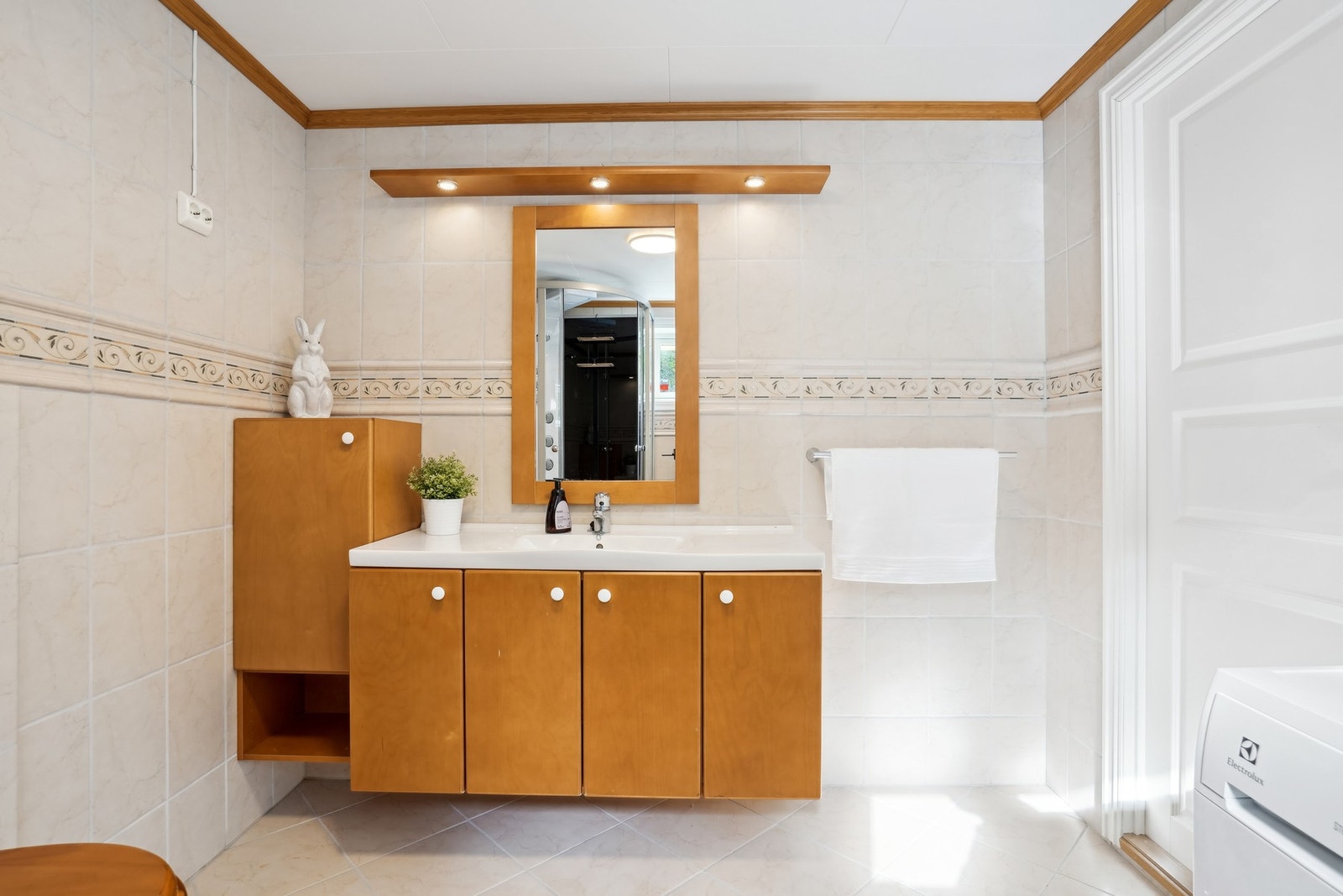 Romslig innredning med speil og spottbelysning over. Galleribilde