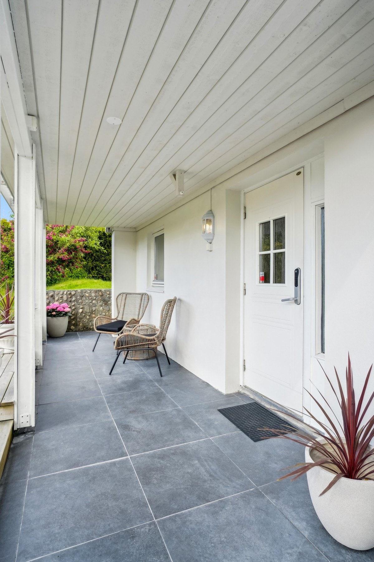 Pent opparbeidet inngangsparti med flislagt terrasse fra 2025. Galleribilde