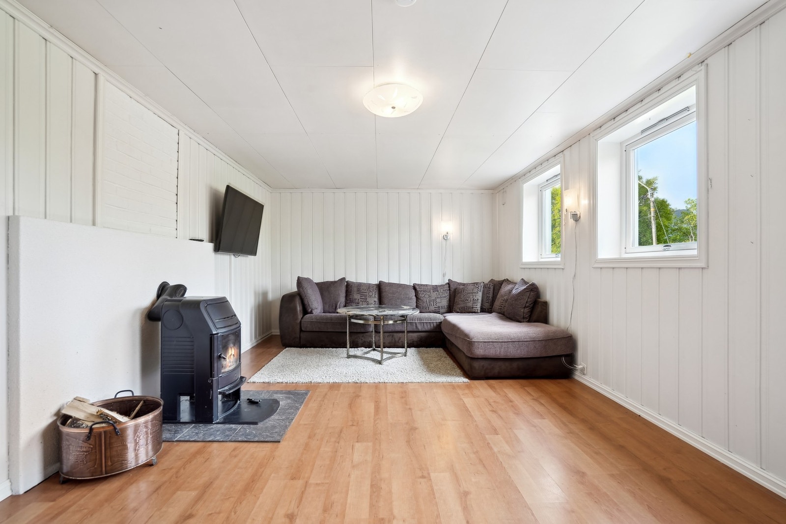 En romslig stue i 1.etg. Det er montert vedovn for god oppvarming. (Denne er ikke bruksendrett, opprinnelig hobbyrom). Galleribilde