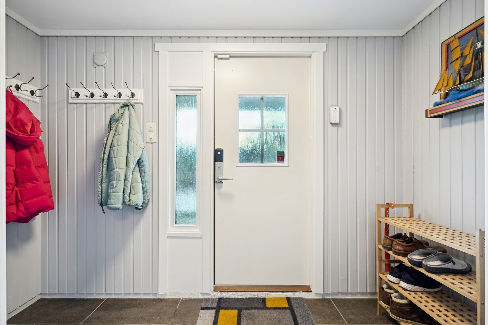 Lys og fin entré med plass til oppbevaring av yttertøy og sko. Det er montert doorman. Galleribilde