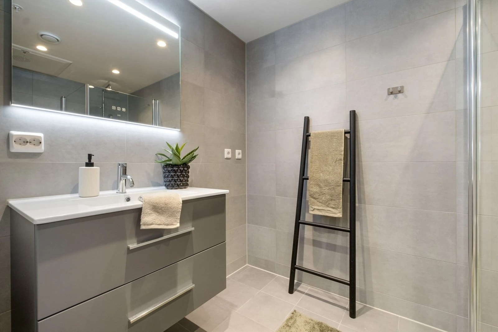 Moderne flislagt hovedbaderom med stilrene fliser på vegger og gulv. Galleribilde