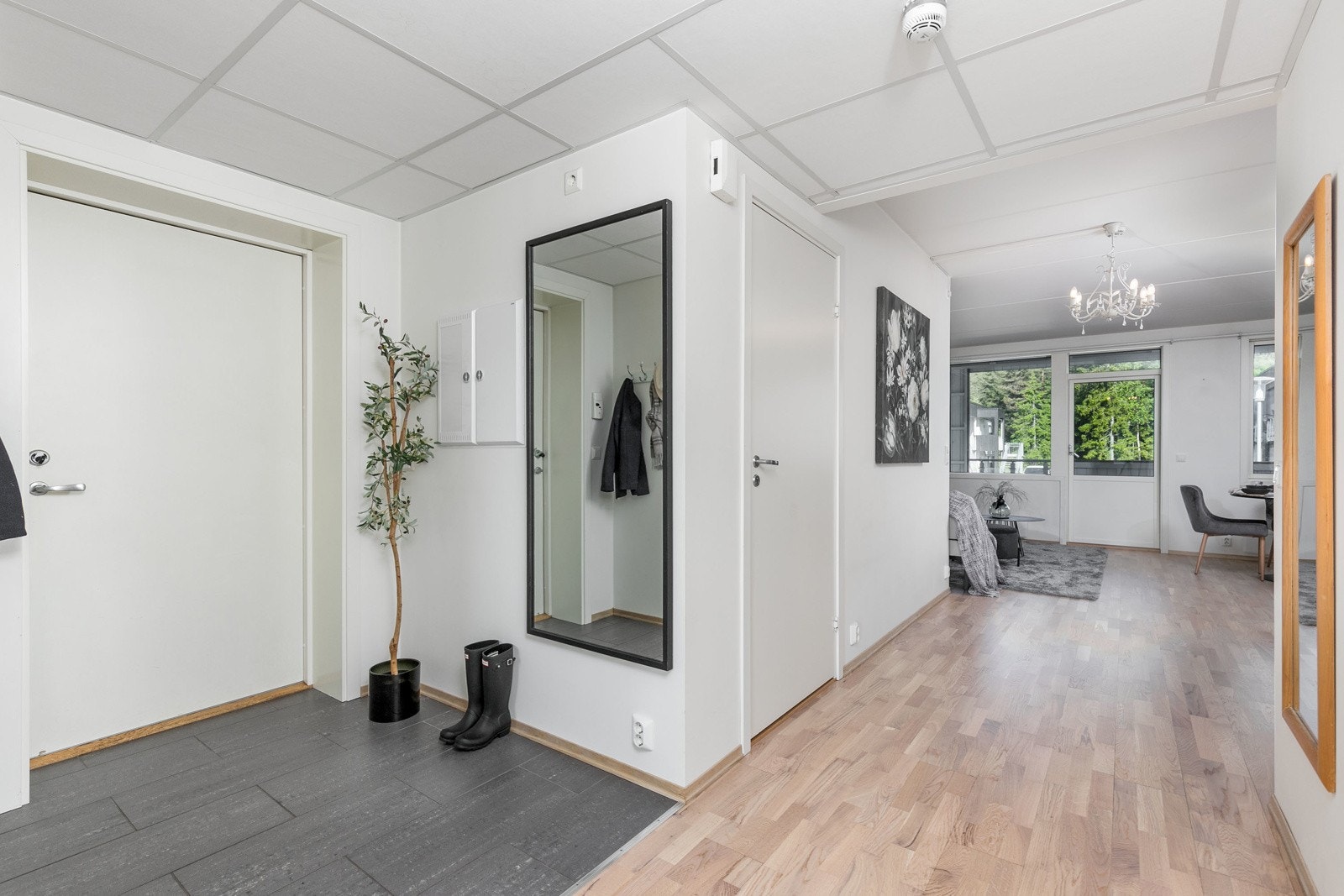 Innbydende entre med lysmalte slette overflater og delikate storformatfliser på gulv, som gir et godt førsteinntrykk av leiligheten. Galleribilde