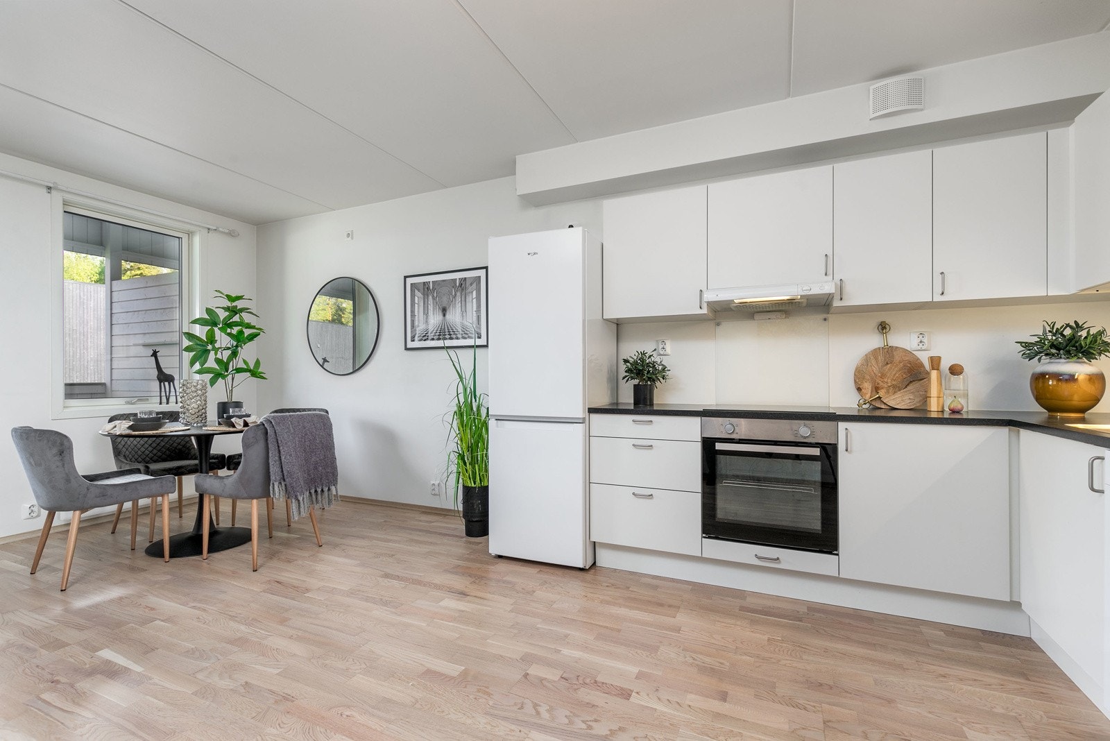 Stilrent og moderne kjøkken fra Norema, nytt i 2019. Innredningen består av hvite slette fronter og laminert benkeplate i mørk utførelse med nedfelt oppvaskkum i rustfritt stål. Galleribilde