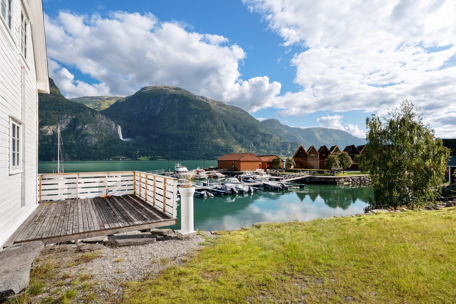 På bakkeplan er det veranda/terrasse mot vest i trekonstruksjonar med rekkverk i tre. Galleribilde