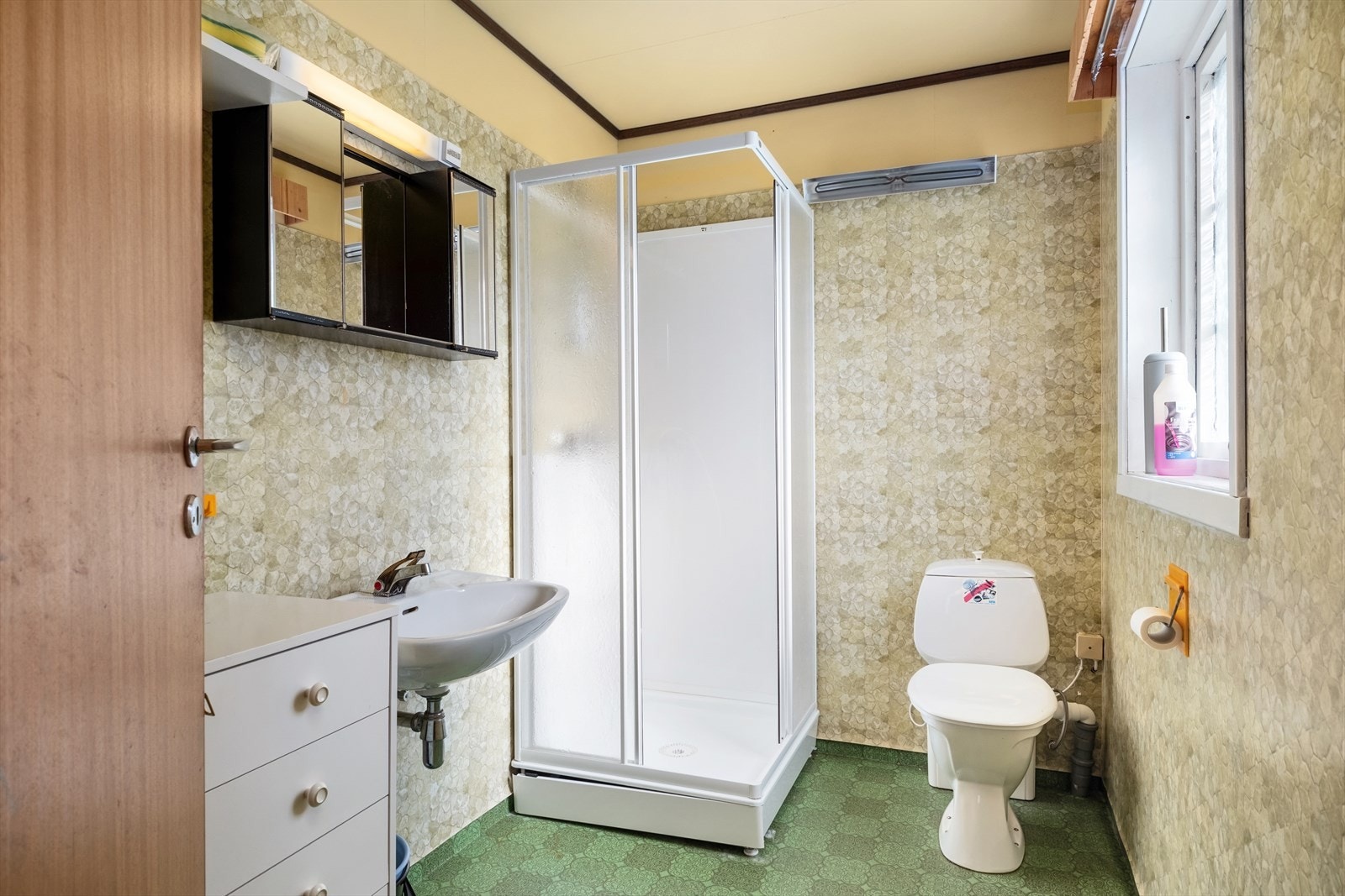 Badet er truleg frå 70-80-talet med belegg på golv og veggar. Galleribilde