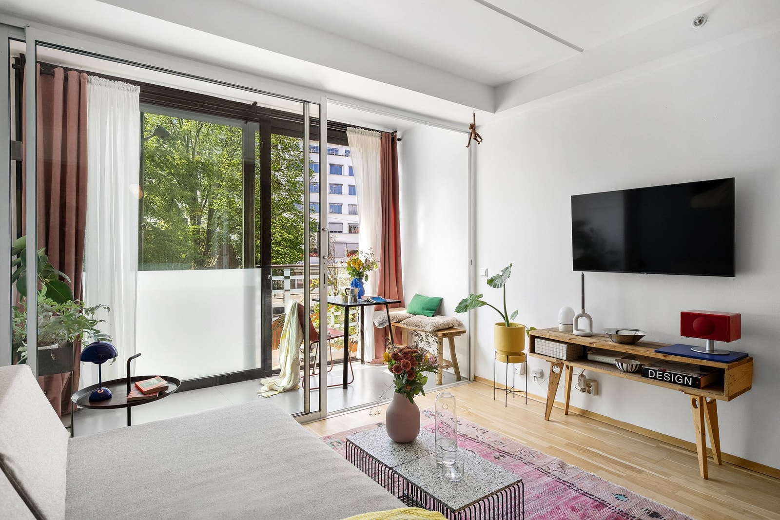 Lys stue med store vindusflater, fra gulv til tak, som sørger for rikelig med dagslys. Galleribilde