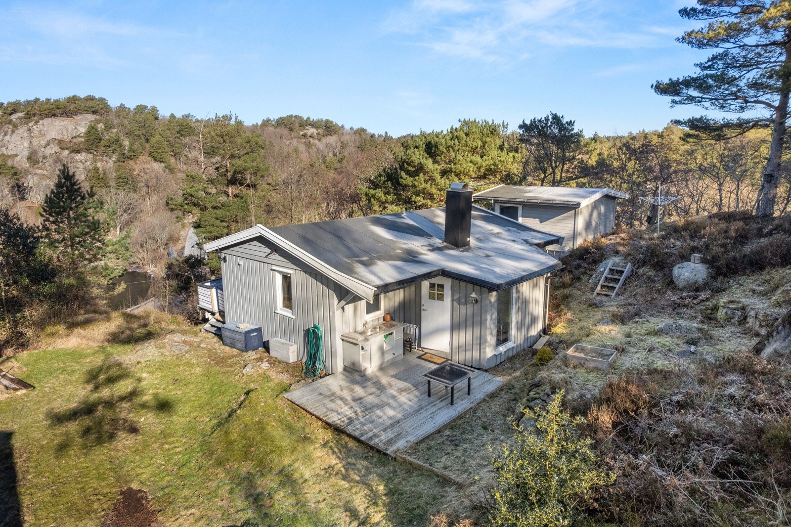 Hytten har treplatting ved inngangspartiet og opparbeidet uteområde med plen. Galleribilde