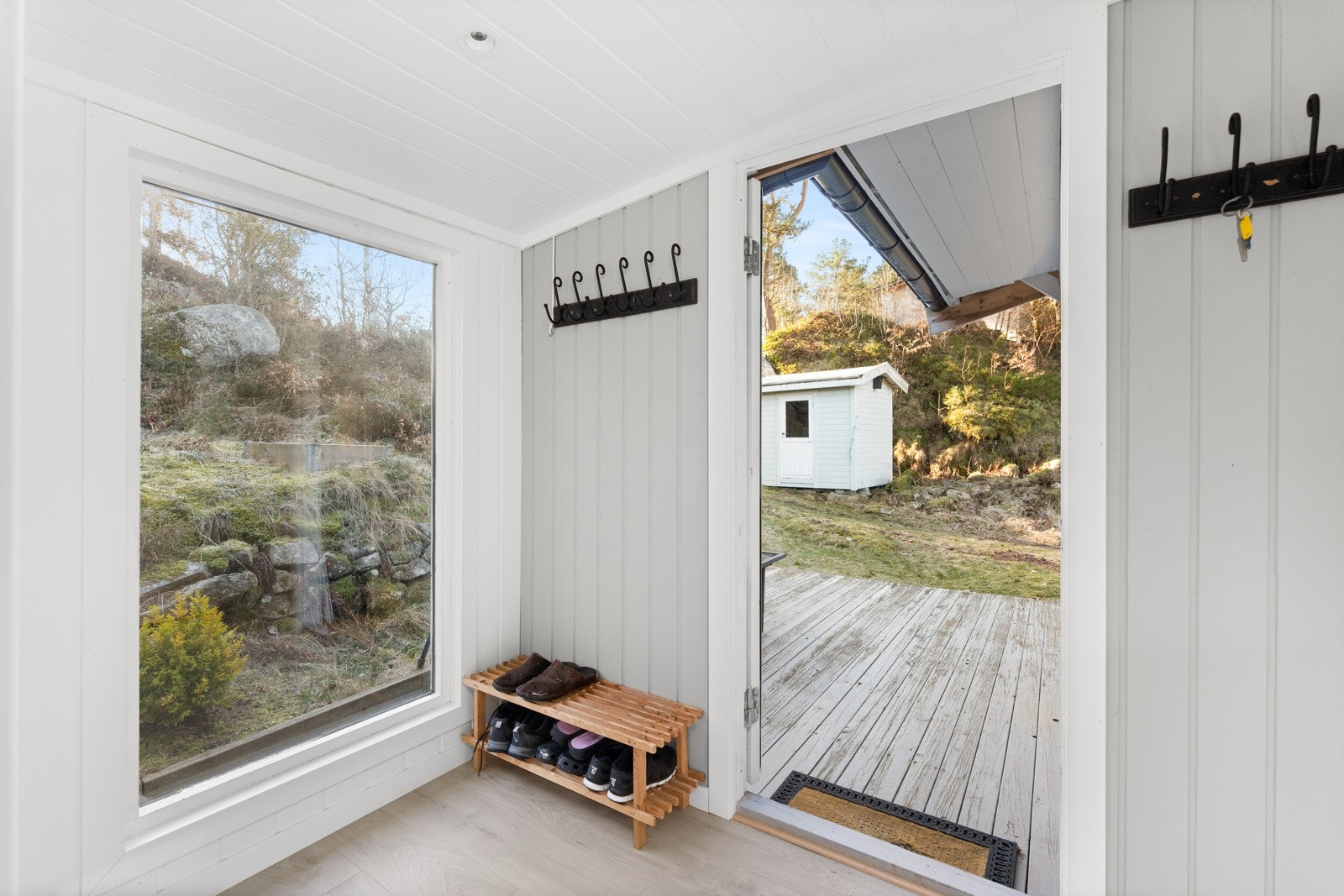 Velkommen inn! Hyggelig inngangsparti med entrè med laminat på gulv, panel på veggene, spotter i tak og stort vindu. Galleribilde