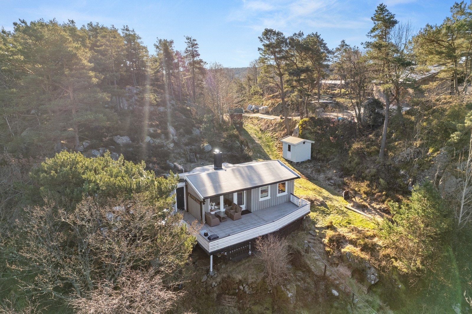 Eiendommen har trapper til hytten og en frittstående redskapsbod. Galleribilde