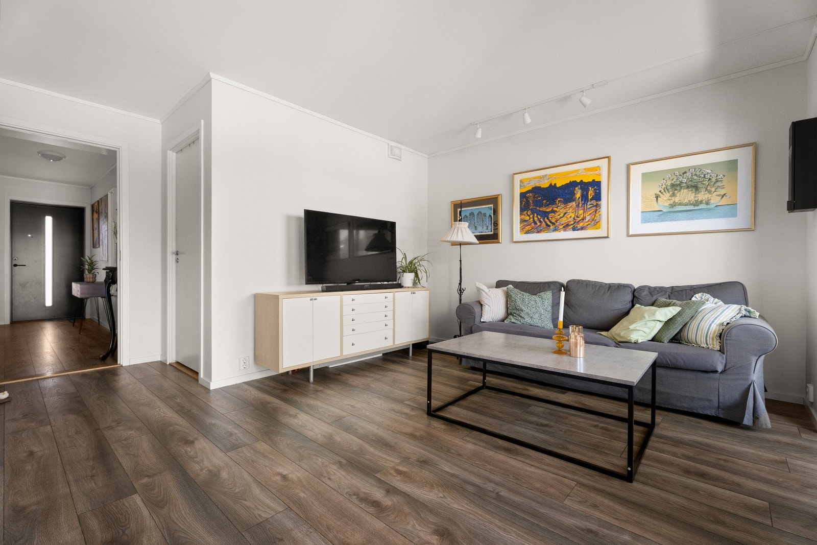 Allrommet har hvitmalte vegger og tidsmessig, enstavs laminatgulv over elektrisk gulvvarme. Galleribilde