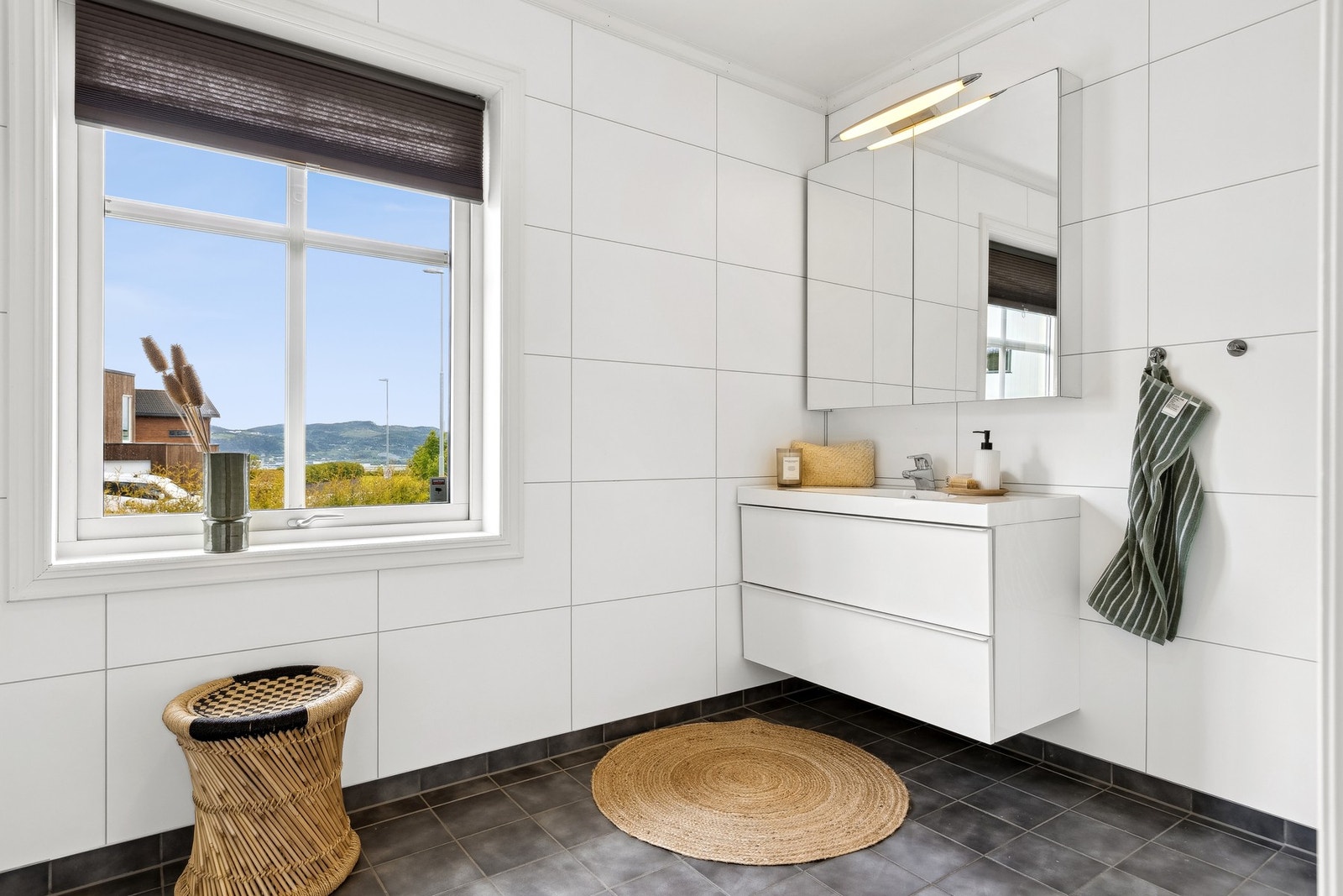 Begge badene i huset er fra byggeår (2014) med flis på gulv og baderomsplater på vegger. Galleribilde