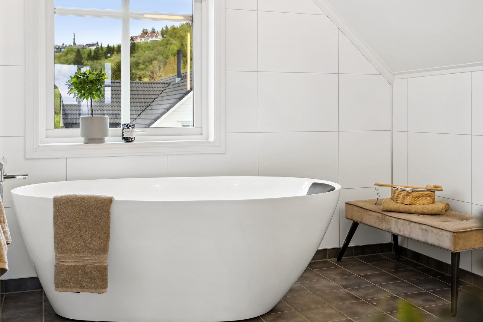 Rommet er stilfullt innredet med dobbel servant, badekar, veggmontert toalett, og oppvarmes med gulvvarme for ekstra komfort. Galleribilde