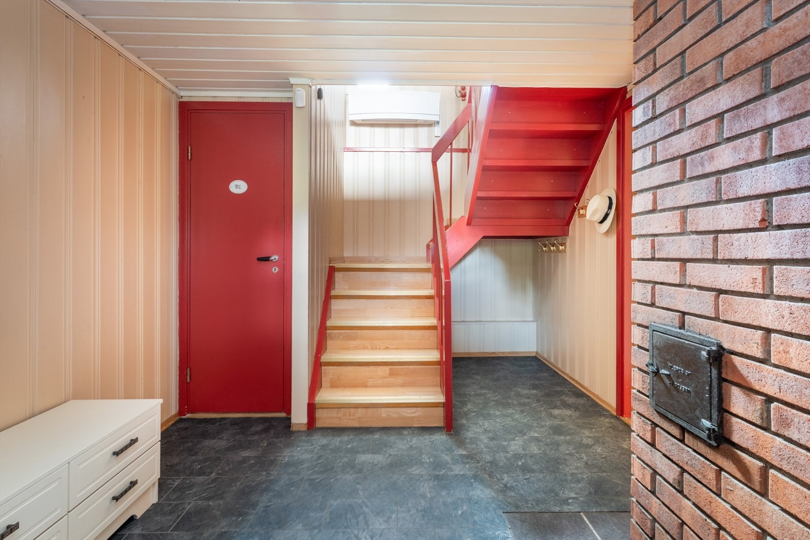 Et praktisk vindfang ønsker deg velkommen inn i boligens underetasje, hvor det er videre tilkomst inn til en romslig hall med trapp opp til hovedetasjen. Galleribilde