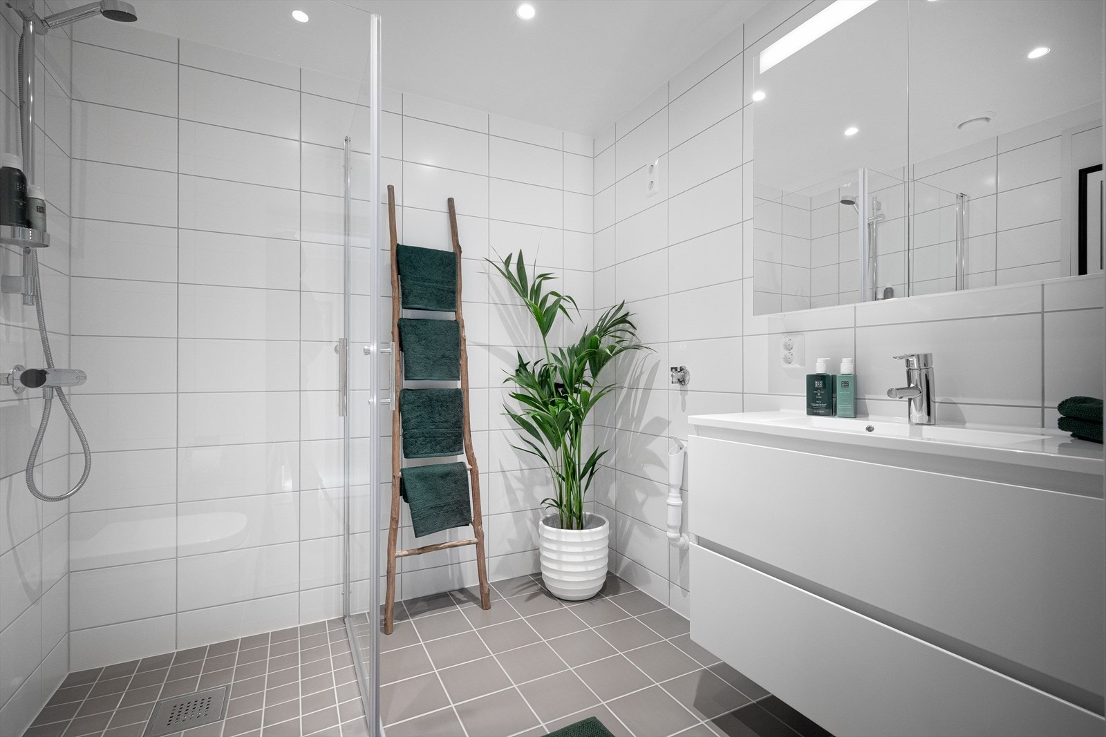 Badet er innredet med baderomsinnredning med servant, vegghengt toalett og dusj med inngående dører som gjør det enkelt å holde rent. Galleribilde