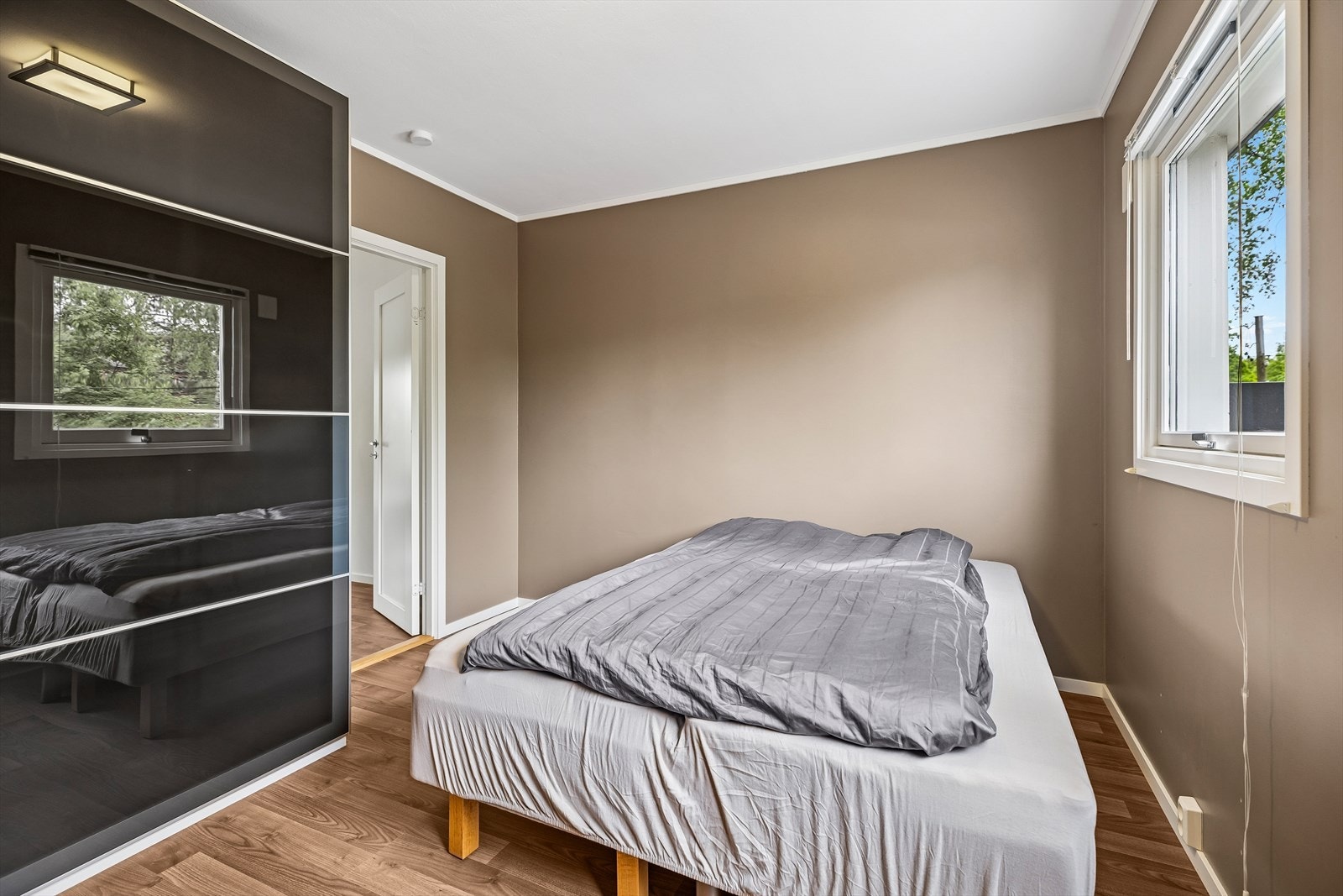 Stor, praktisk skyvedørsgarderobe med glatte fronter. Galleribilde