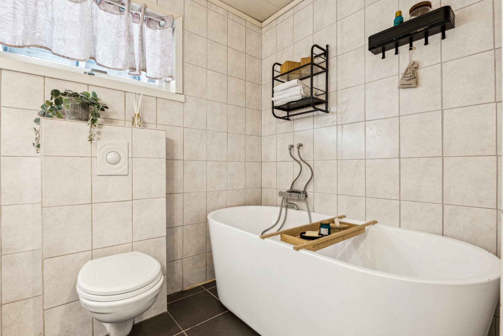 Stilrent bad med både badekar og vegghengt toalett. Galleribilde