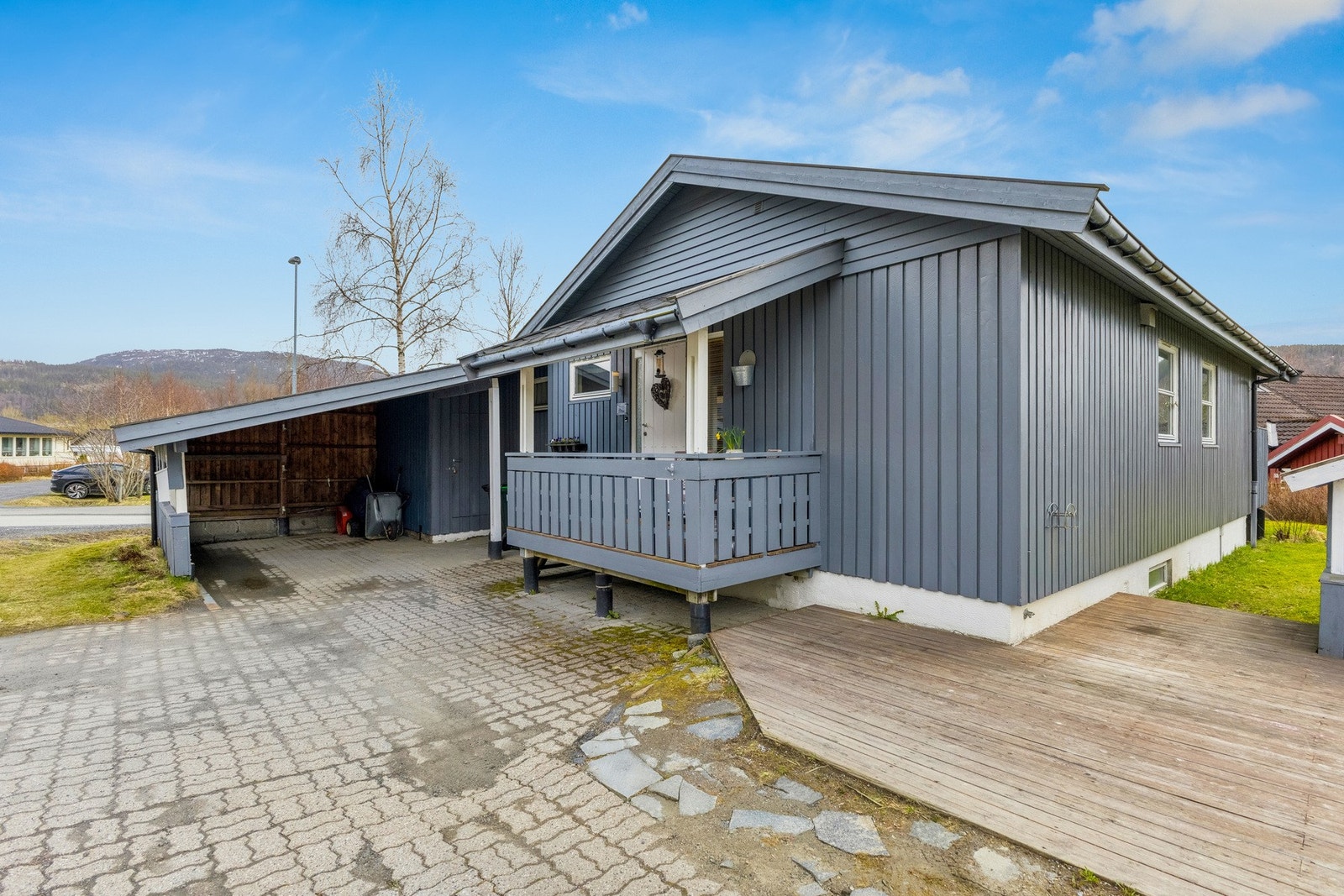 Brosteinlagt innkjørsel og mer terrasse som binder huset og lekestua sammen. Galleribilde