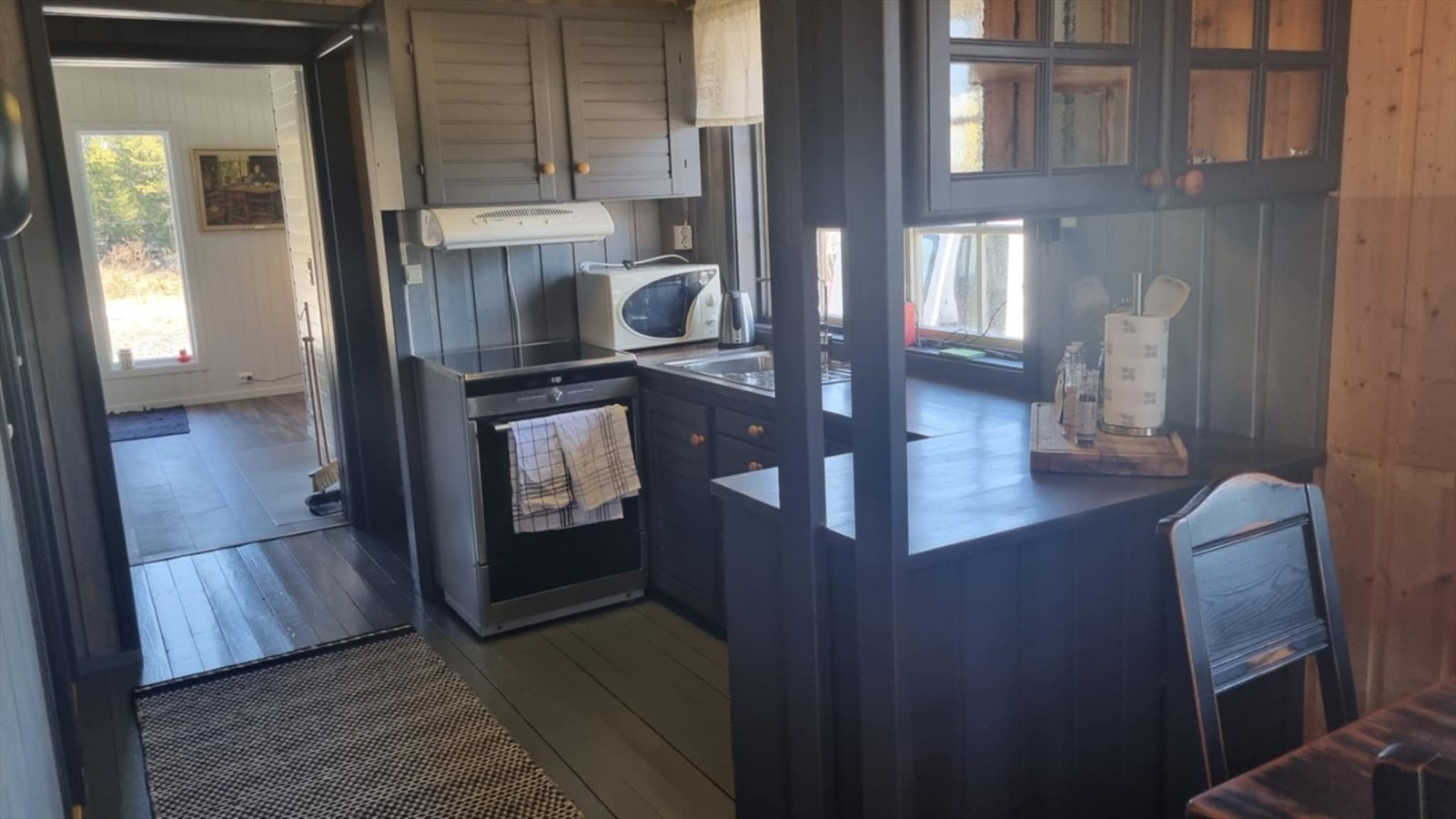 Kjøkkenet er innredet med oppvaskkum, komfyr og mikrobølgeovn. Galleribilde