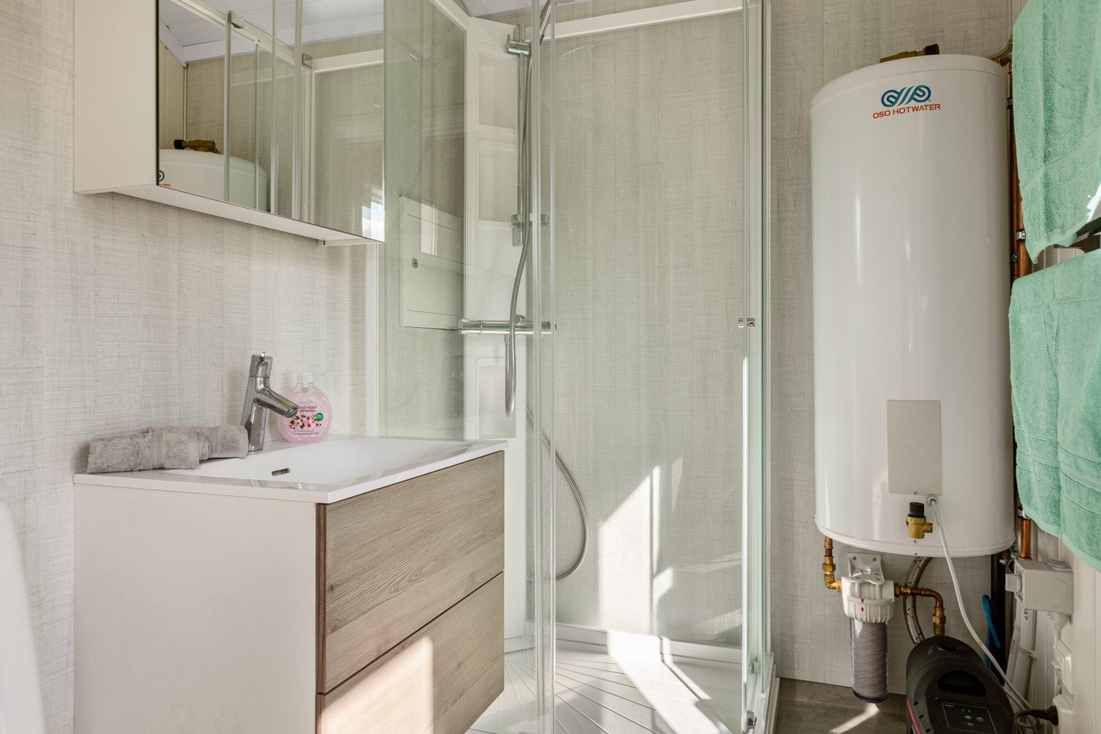 Badet er innredet med servantskap med skuffer og overskap, dusjkabinett og toalett. Galleribilde