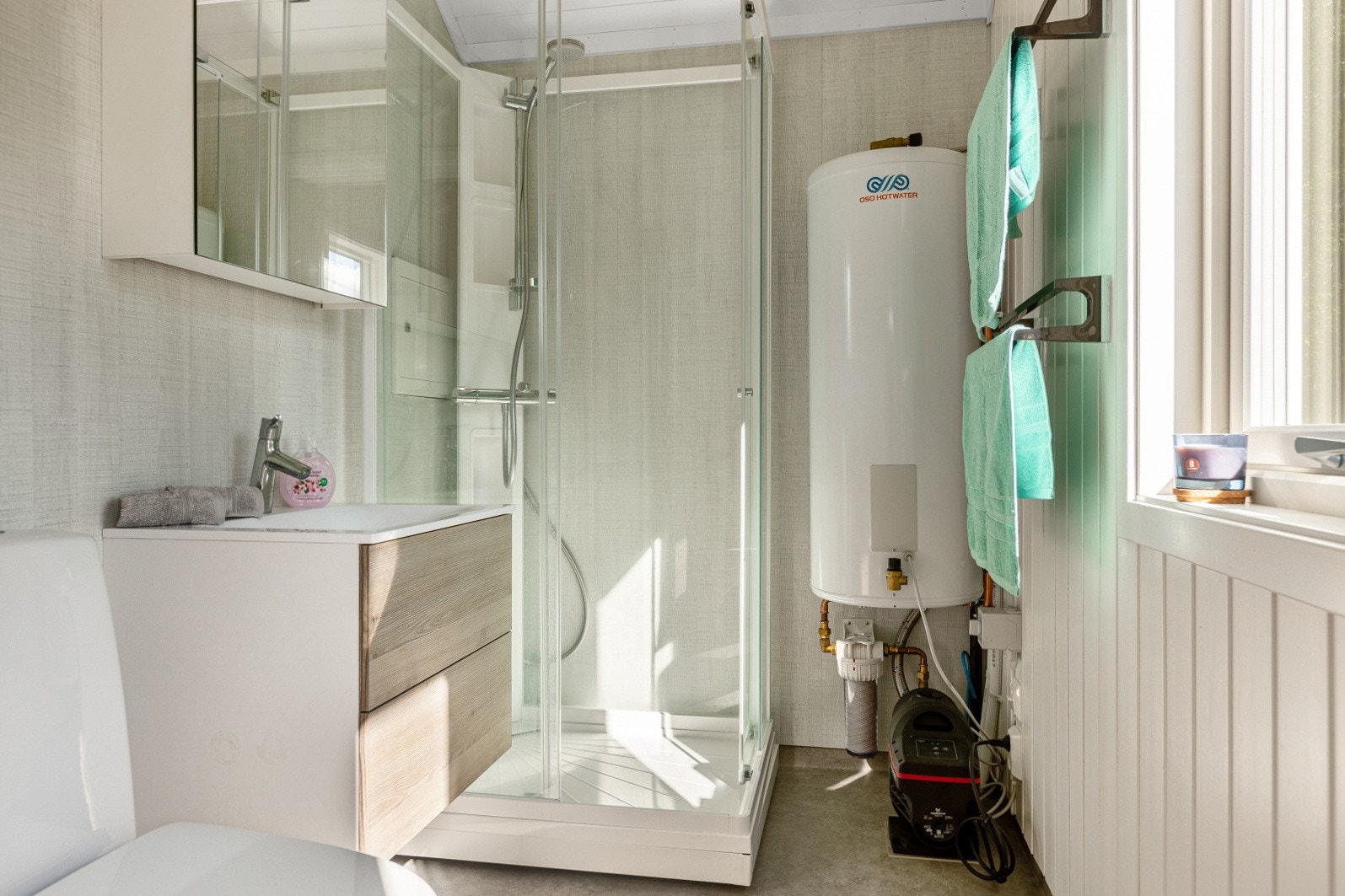 Bad med panel og baderomsplater på vegger, på gulv er det gulvbelegg med varme. Galleribilde