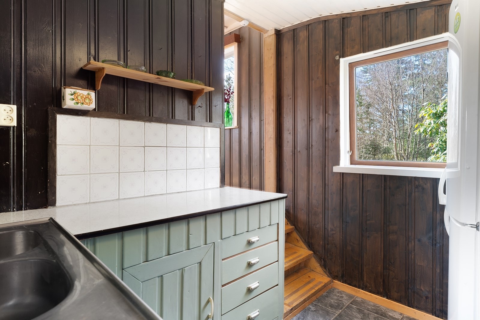 Plassbygget kjøkkeninnredning med malt trepanel og laminat benkeplate Galleribilde