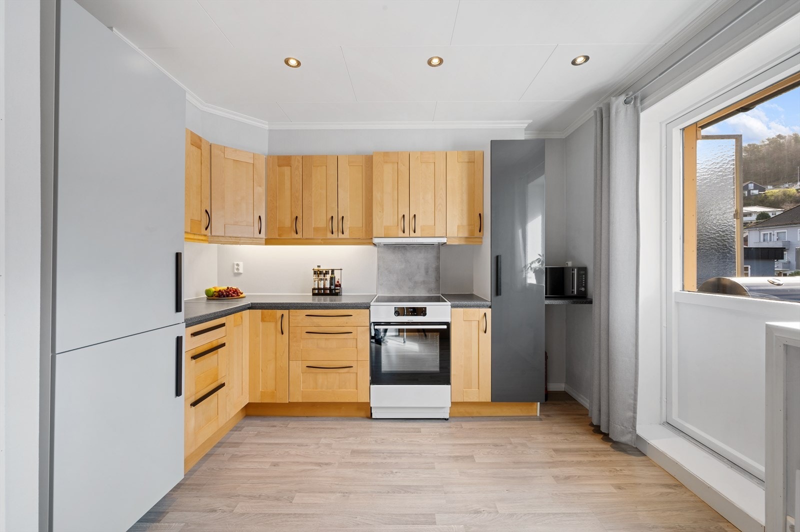 Klassisk IKEA kjøkkeninnredning med laminert benkeplate og profilerte fronter. Galleribilde