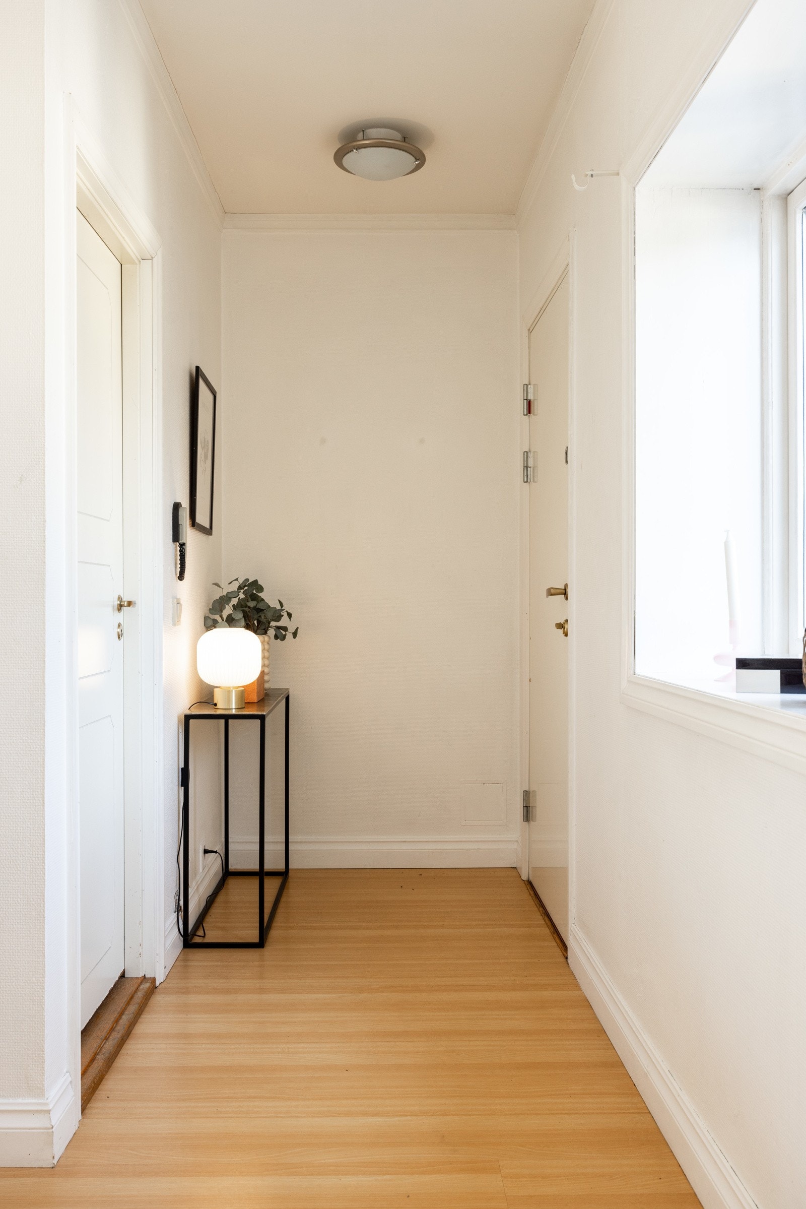 Man ankommer leiligheten i en innbydende entré med plass til oppheng av yttertøy på veggen - Velkommen inn! Galleribilde