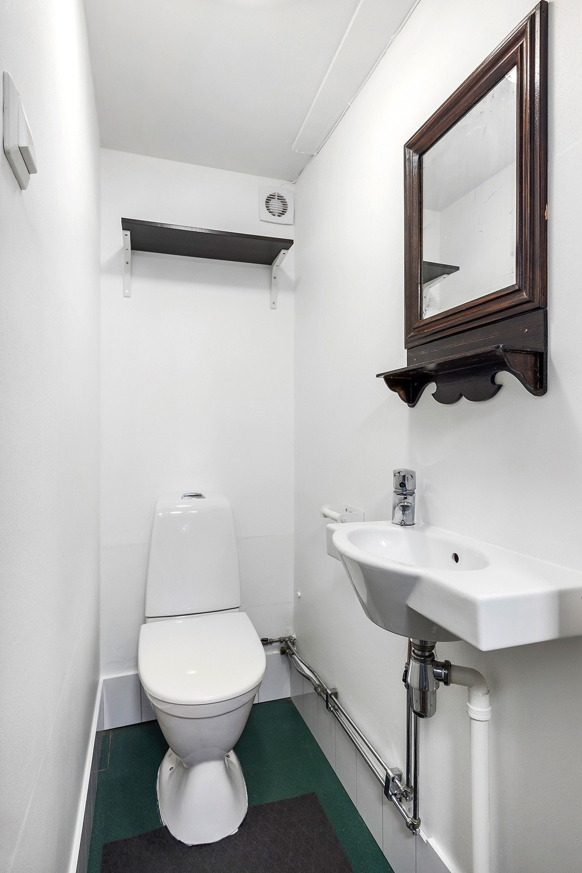 Toalettrom har en innredning bestående av toalett og servant. Galleribilde