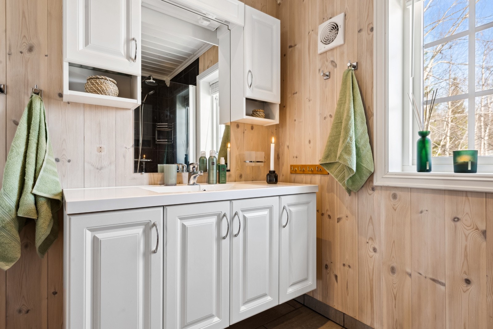 Badet har flislagt gulv med varme og vegghengt servantinnredning. Galleribilde