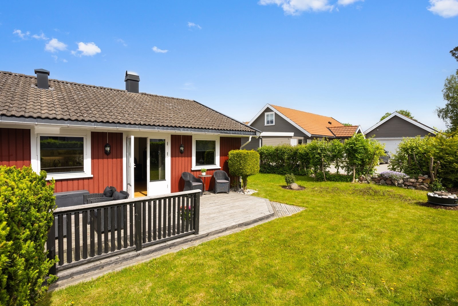 Praktisk adkomst fra stue til terrasse og hage. Denne skjermende uteplassen med tredekke og nedtrapping til hagen, blir nærmest som en "ekstra stue" i sommerhalvåret. Galleribilde