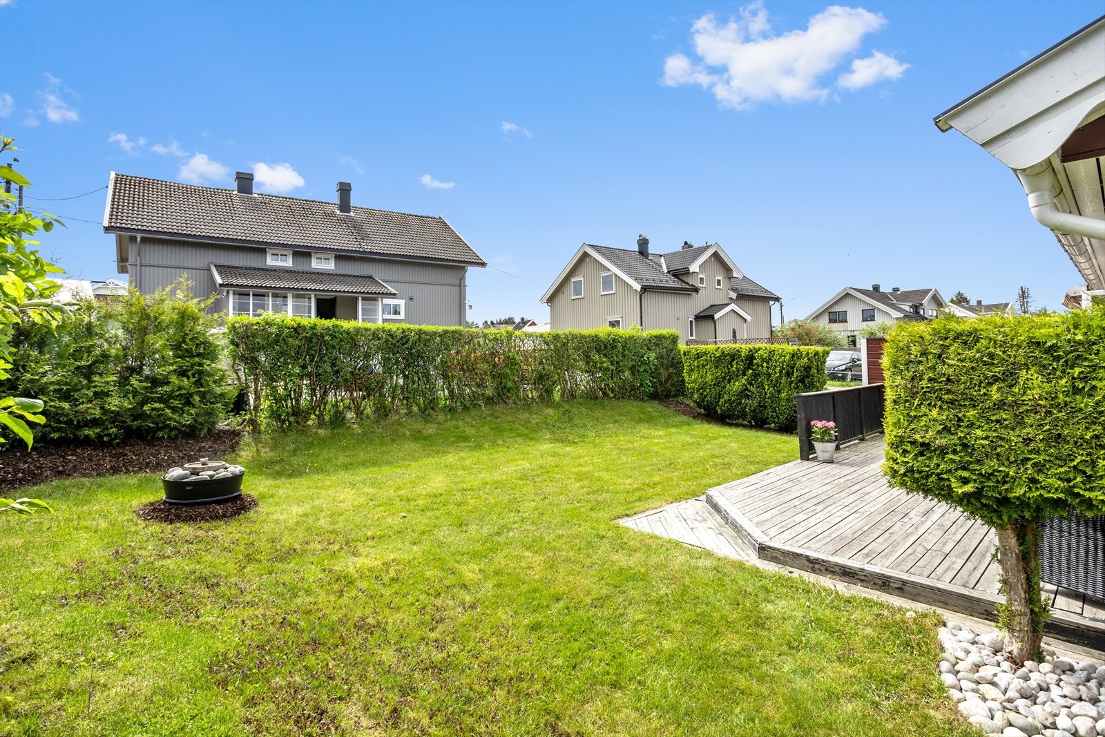 Eiendommen har en pent opparbeidet og lettstelt tomt med flat plen, omkranset av hekk og prydbusker som gir god skjerming mot naboer. Hagen er i det vesenltige sydvendt og solrik med en fin treplatting utenfor stue og kjøkken. Galleribilde