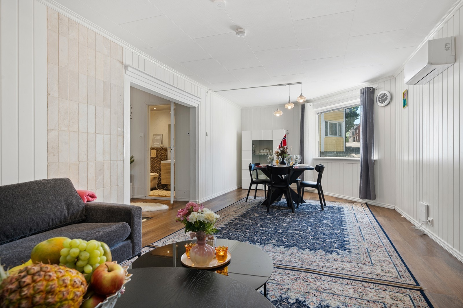 Stue med lys fargevalg og laminat på gulvet. Her er det montert varmepumpe. Galleribilde