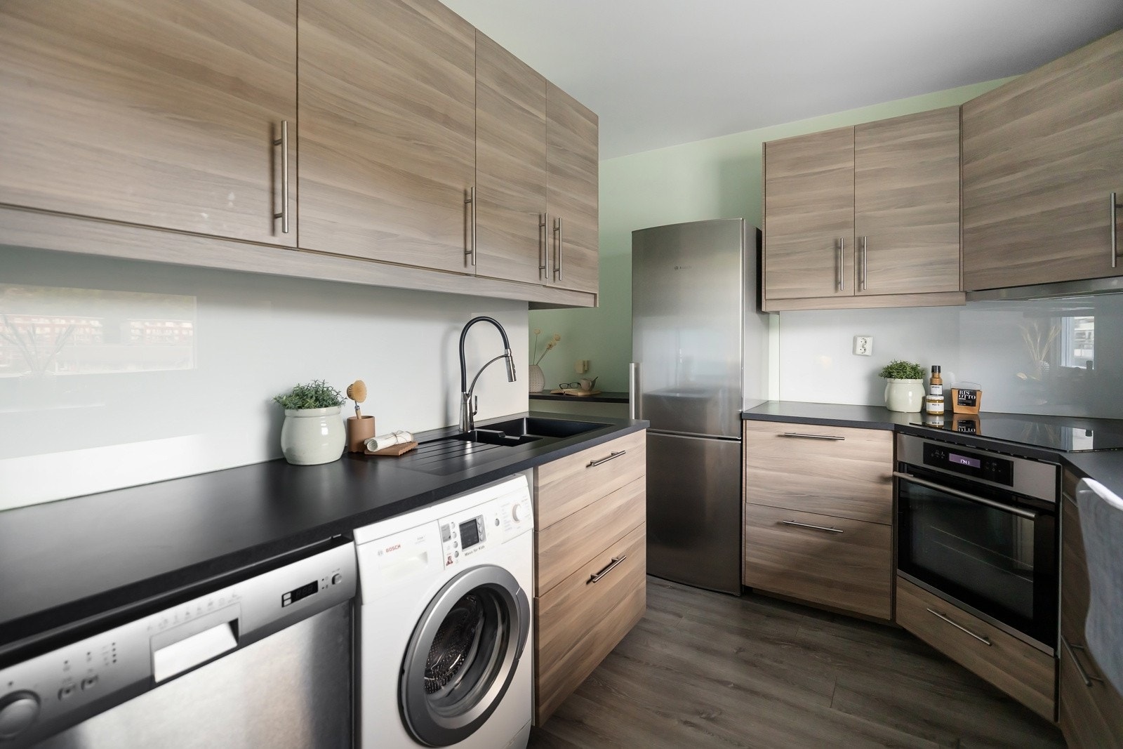 Pent kjøkken som har godt med skap- og benkeplass Galleribilde