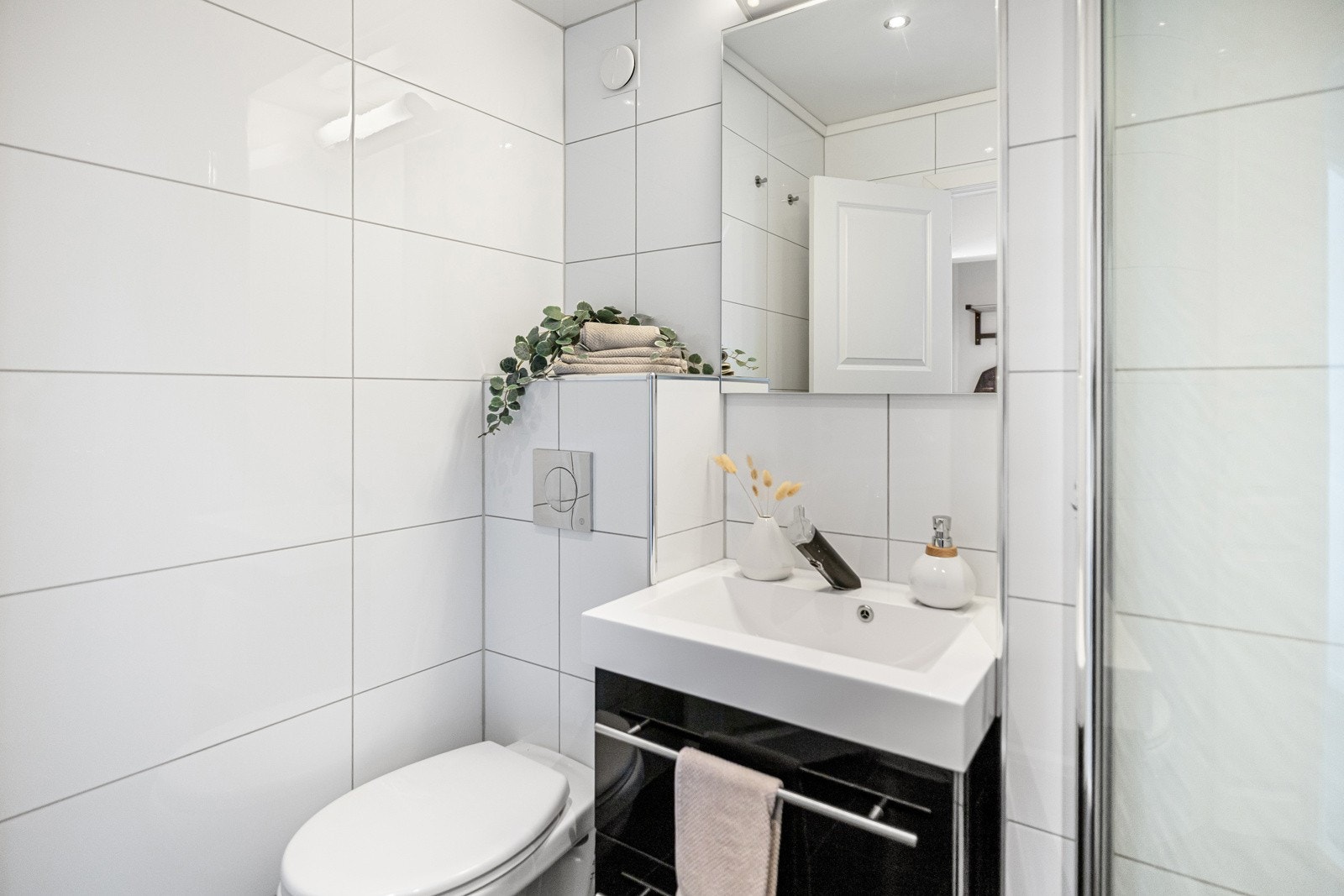 Lekkert bad med vegghengt toalett, dusj og servant Galleribilde