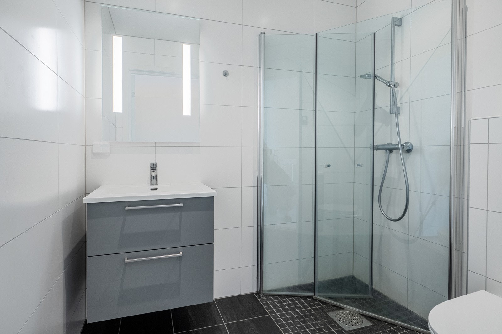 Bad i 3.etasje er innredet med dusjvegger, toalett og servantinnredning. Galleribilde