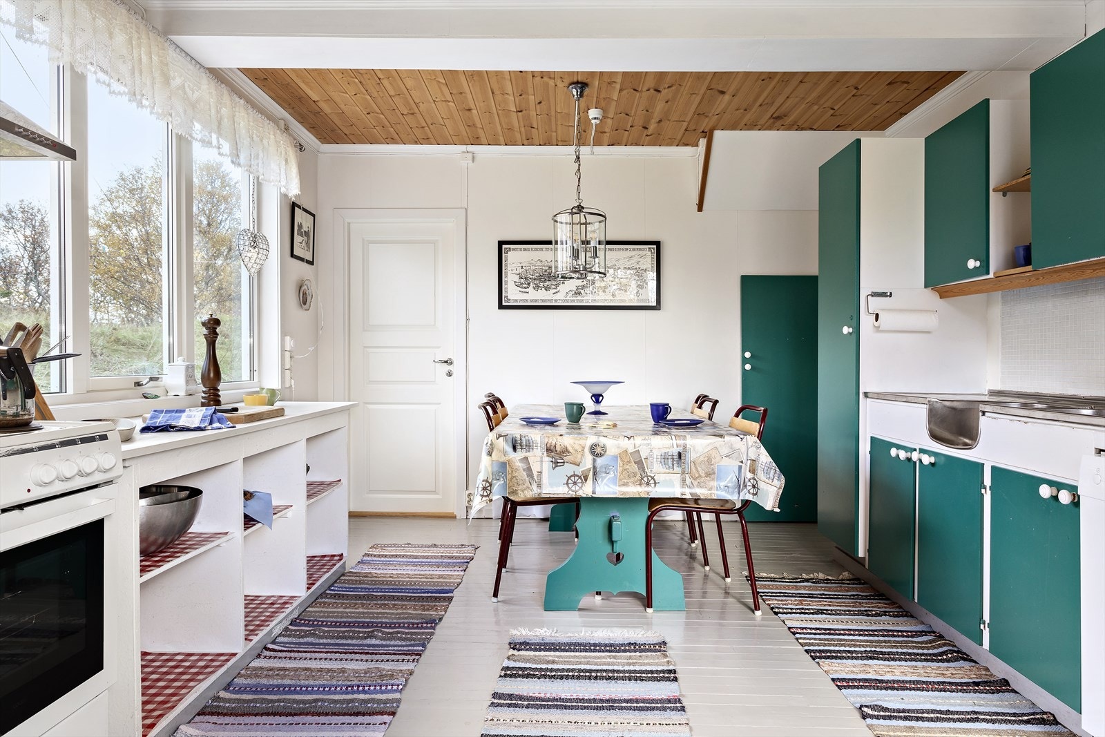 Kjøkkenet har en litt eldre men funksjonell innredning. Det er malte tregulv og malte veggplater på kjøkkenet. Galleribilde